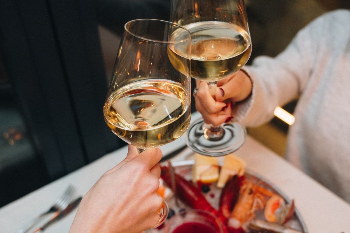 Amici brindano all'aperto con calici di vino e spritz da Il Cestino Milano