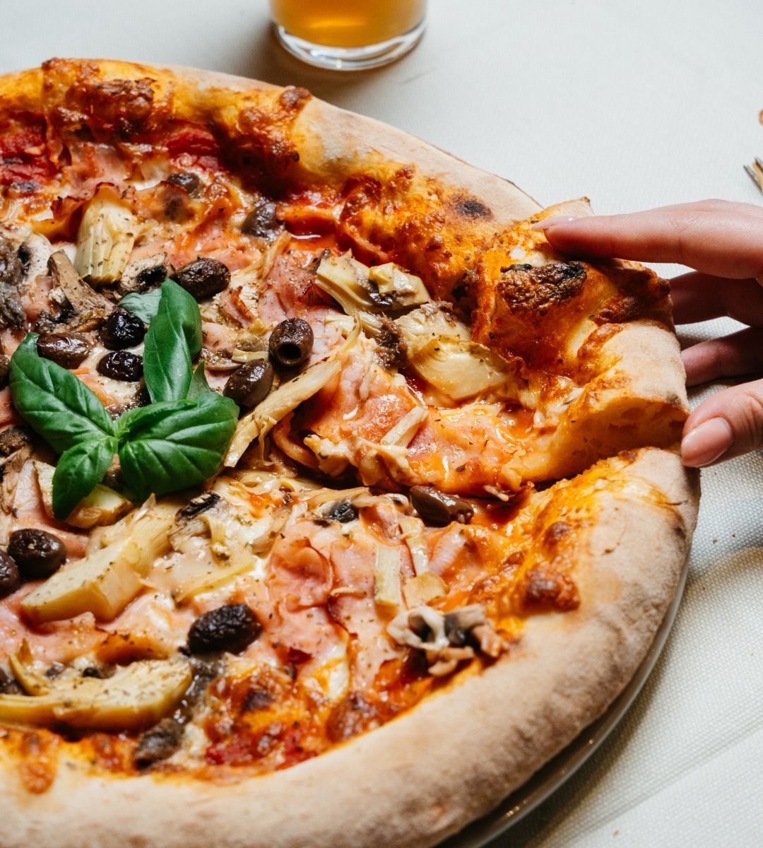 Pizza farcita con carciofi e olive servita presso la trattoria di pesce milano Pizza farcita con carciofi e olive servita presso la trattoria di pesce milano